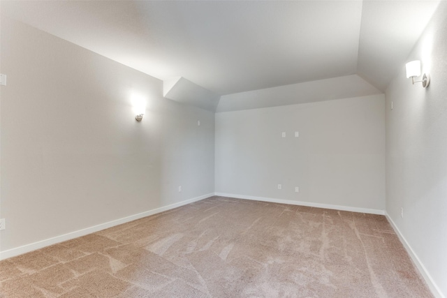 carpeted spare room with lofted ceiling