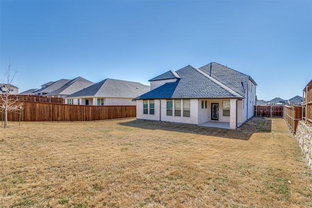 rear view of house with a lawn and a patio