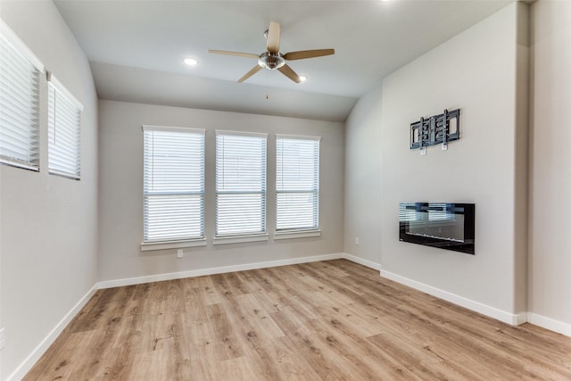 unfurnished living room featuring ceiling fan, vaulted ceiling, and light wood-type flooring