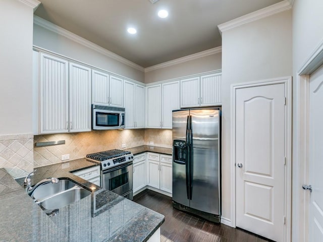 kitchen featuring sink, white cabinetry, ornamental molding, decorative backsplash, and stainless steel appliances