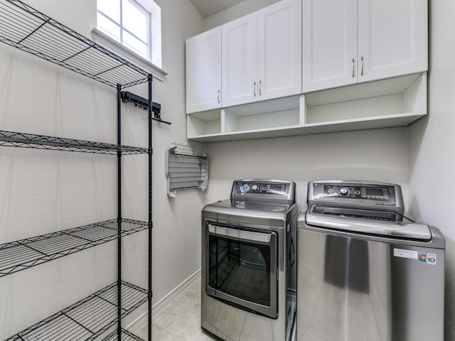 laundry area with cabinets, separate washer and dryer, and light tile patterned floors