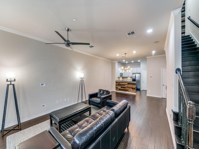 living room featuring crown molding, dark wood-type flooring, and ceiling fan with notable chandelier