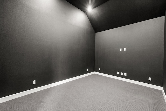 unfurnished room featuring lofted ceiling and carpet flooring