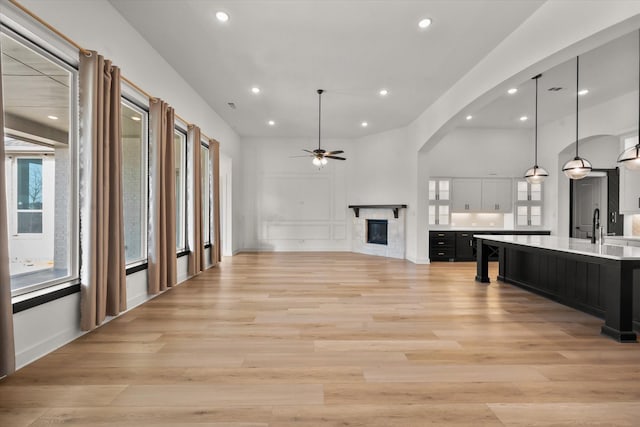 interior space with sink, ceiling fan, and light wood-type flooring