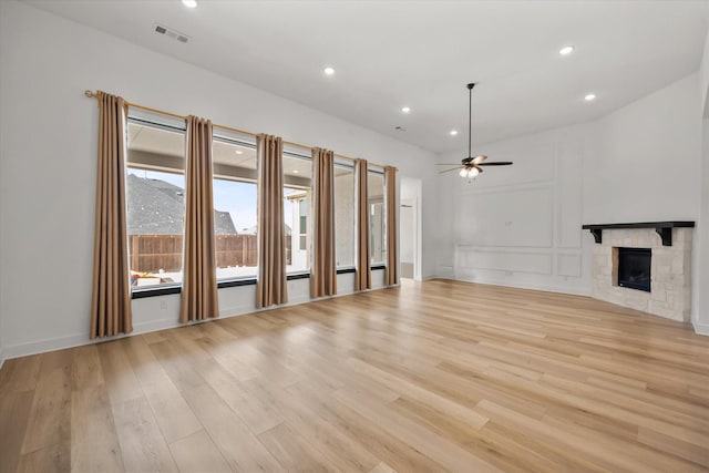 unfurnished living room featuring ceiling fan, a fireplace, and light hardwood / wood-style floors