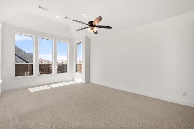 spare room with vaulted ceiling, light carpet, and ceiling fan