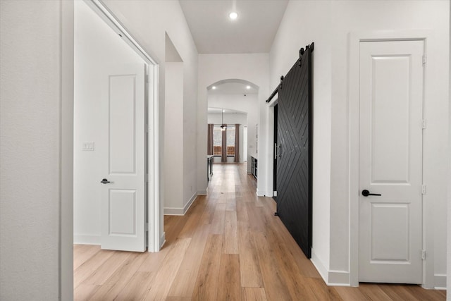 corridor featuring a barn door and light hardwood / wood-style floors