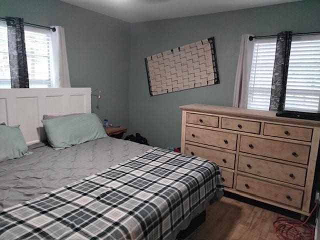 bedroom with dark hardwood / wood-style flooring