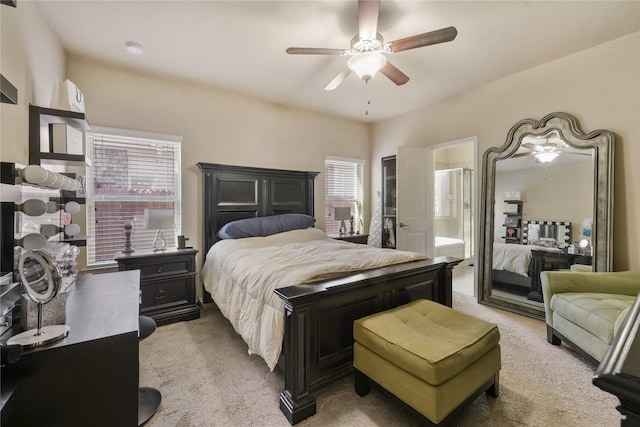 carpeted bedroom featuring ceiling fan and ensuite bath