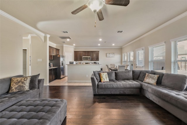 living room with crown molding, a healthy amount of sunlight, and hardwood / wood-style floors