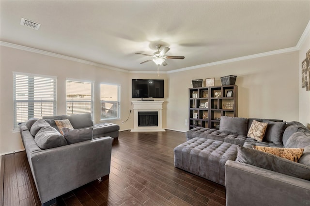 living room with dark wood-type flooring, ceiling fan, and crown molding