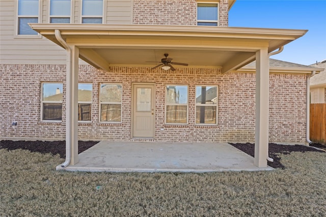 doorway to property featuring a yard, a patio area, and ceiling fan