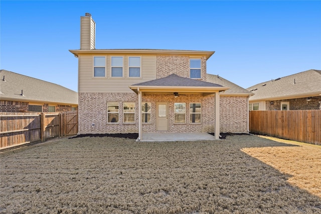 rear view of property featuring a yard and a patio