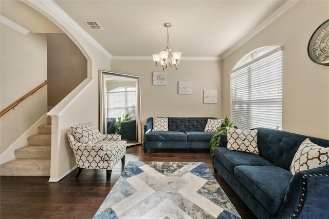 living room with dark wood-type flooring, ornamental molding, and an inviting chandelier