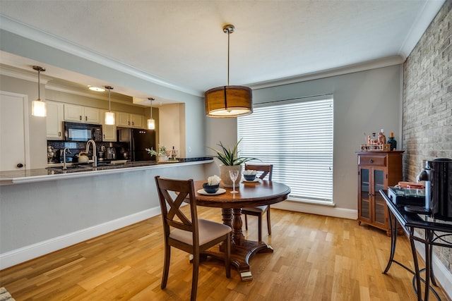 dining room with crown molding, a healthy amount of sunlight, and light hardwood / wood-style floors