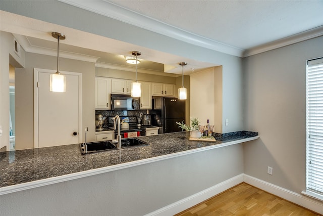 kitchen featuring pendant lighting, backsplash, black appliances, light hardwood / wood-style floors, and white cabinets