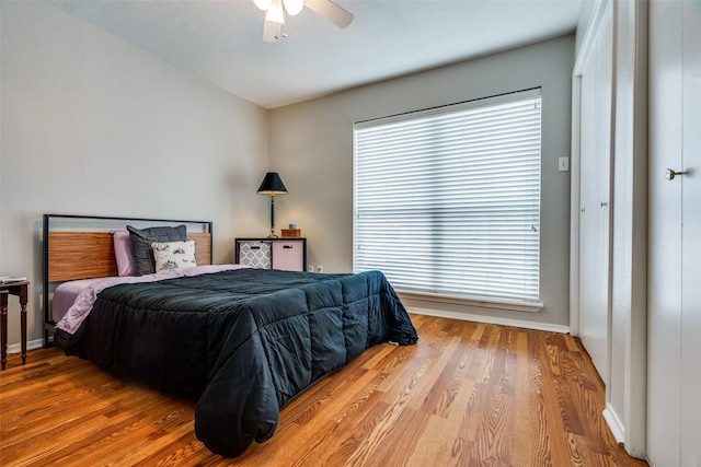 bedroom with ceiling fan, light hardwood / wood-style floors, and multiple windows