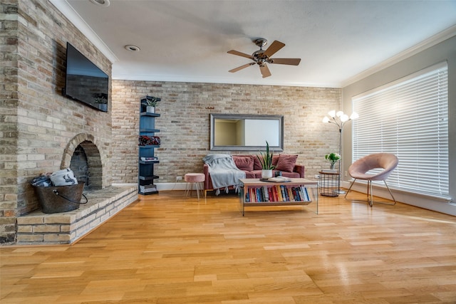 living room featuring crown molding, ceiling fan, and light wood-type flooring