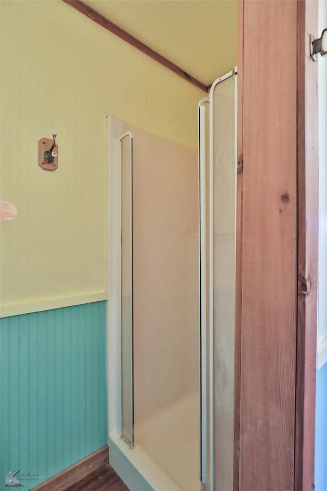 bathroom featuring a shower with shower door and hardwood / wood-style flooring