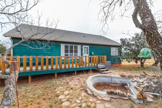 back of property featuring central AC unit and a wooden deck