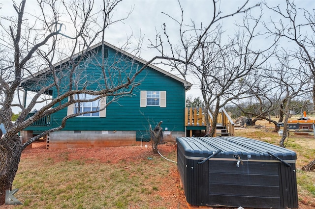 view of property exterior featuring a yard and a hot tub