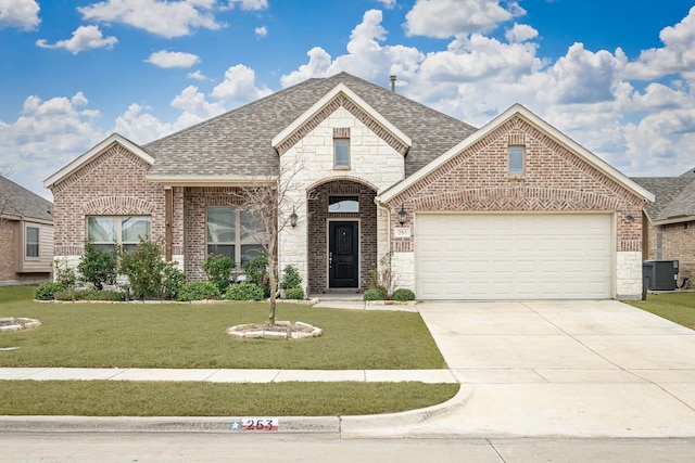 view of front of house with a garage, central AC unit, and a front lawn