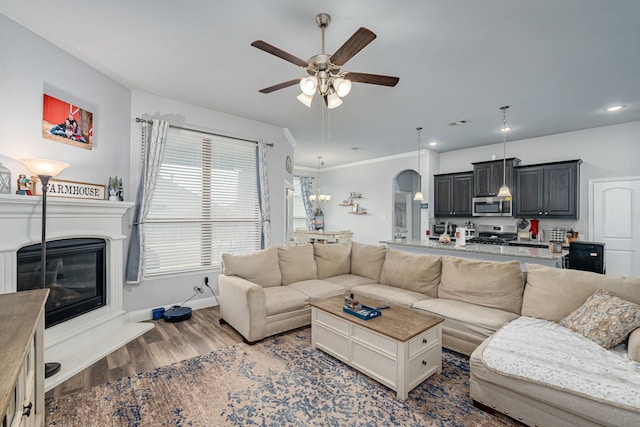 living room with ceiling fan, ornamental molding, and dark hardwood / wood-style flooring