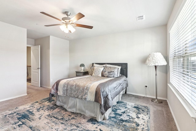 carpeted bedroom with multiple windows and ceiling fan