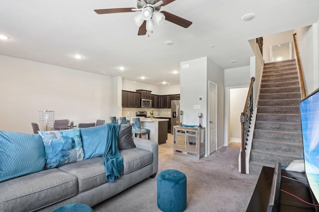 carpeted living room with ceiling fan