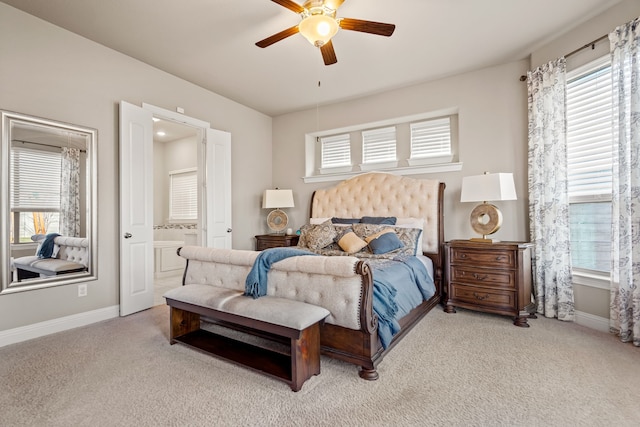 bedroom featuring light carpet, connected bathroom, and ceiling fan