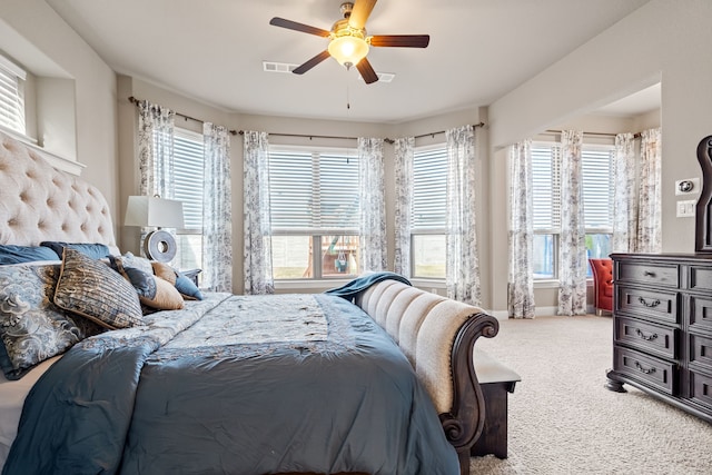 carpeted bedroom with ceiling fan and multiple windows