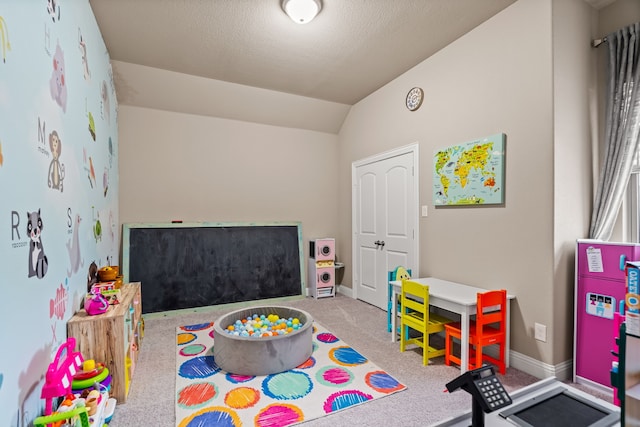 rec room with a textured ceiling, light carpet, and lofted ceiling