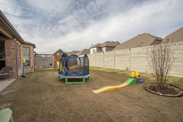 view of play area featuring a yard and a trampoline