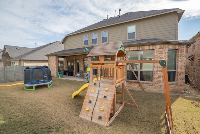 view of play area with a yard, a patio, and a trampoline