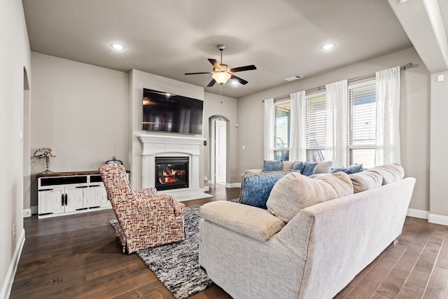 living room with ceiling fan and dark hardwood / wood-style flooring