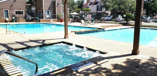 view of pool featuring a community hot tub and a patio area