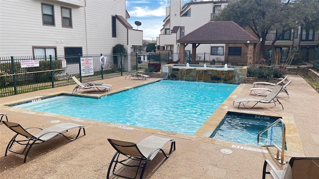 view of pool with a hot tub, a gazebo, pool water feature, and a patio area