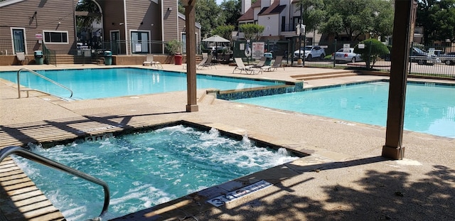 view of pool featuring a community hot tub and a patio area