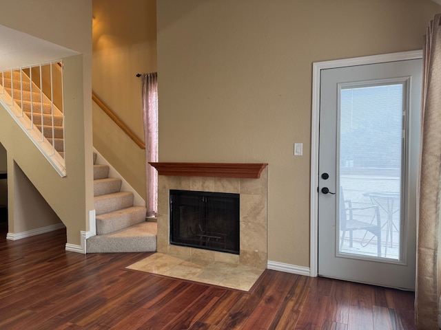 unfurnished living room with hardwood / wood-style floors and a tile fireplace