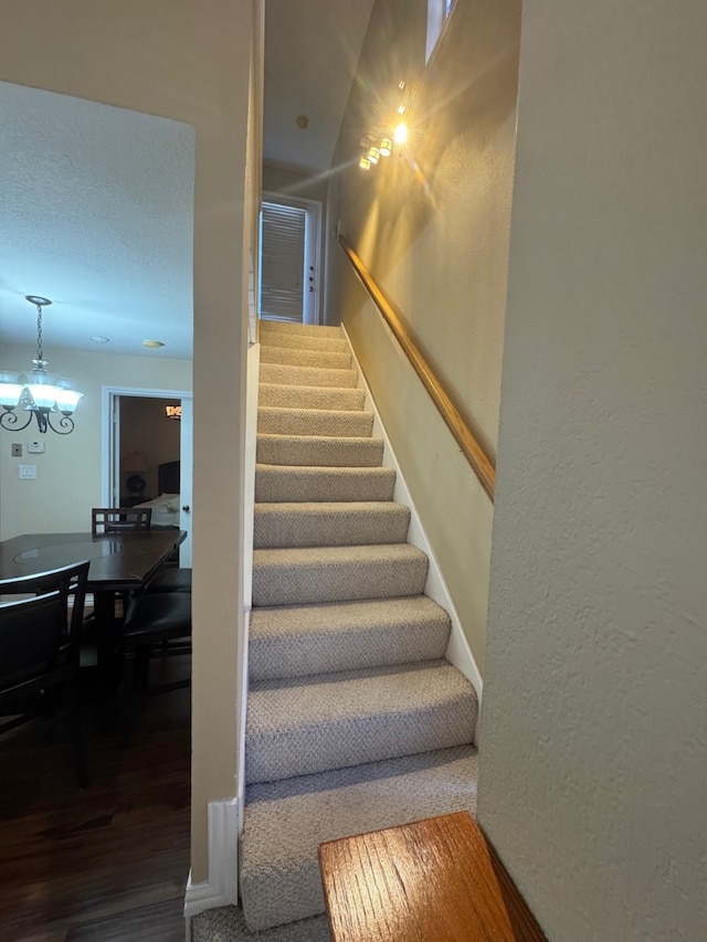 stairs featuring an inviting chandelier and hardwood / wood-style floors