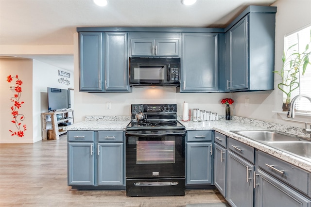 kitchen featuring sink, light hardwood / wood-style flooring, and black appliances