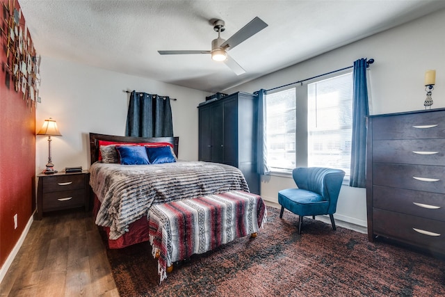 bedroom featuring dark hardwood / wood-style floors, a textured ceiling, and ceiling fan