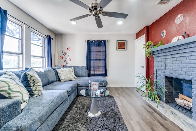 living room with ceiling fan, a fireplace, and hardwood / wood-style floors