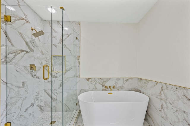 bathroom featuring tile walls and separate shower and tub