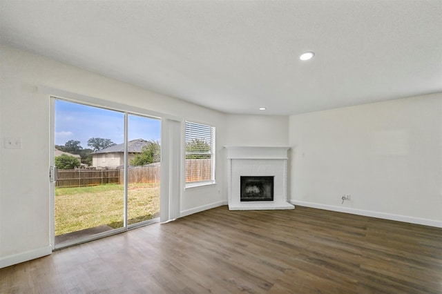 unfurnished living room featuring hardwood / wood-style flooring and a brick fireplace