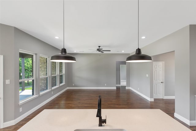 interior space featuring ceiling fan, a wealth of natural light, and dark hardwood / wood-style flooring