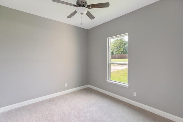 carpeted spare room with ceiling fan