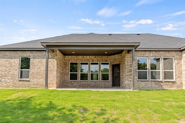 rear view of house with a yard and a patio