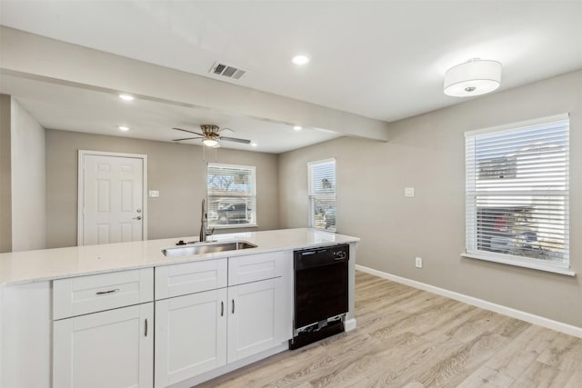 kitchen featuring sink, plenty of natural light, white cabinetry, and black dishwasher