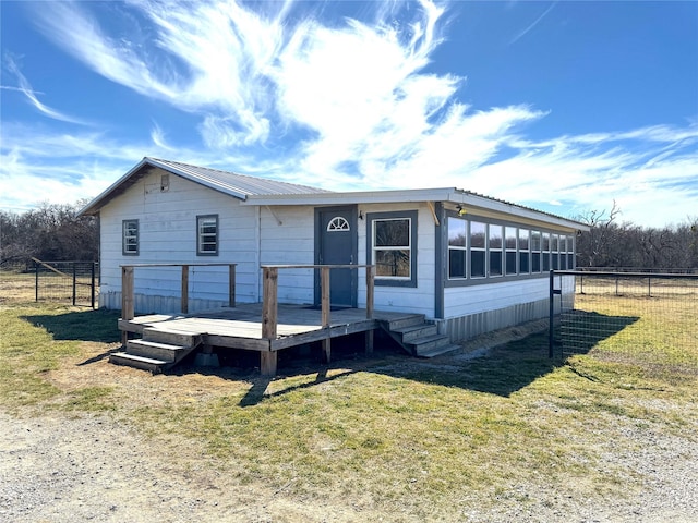 manufactured / mobile home featuring a front yard, fence, and a wooden deck